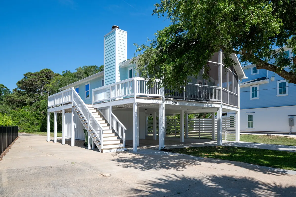 The elevated deck and white staircase of The Holland House provide a perfect vantage point to enjoy outdoor gatherings, sunbathing, or a quiet morning coffee. The deck's connection to the outdoors echoes the easy beach access described in the text.